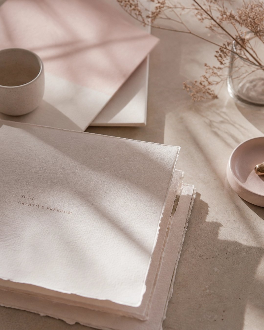 Soft flatlay of handmade paper notebooks and dried botanics reading 'Soul — Creative Freedom' — representing the alignment between operational systems and founder vision in Seattle businesses