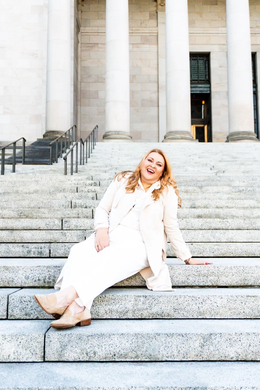 Andrea laughing in an ivory outfit on the Capitol steps