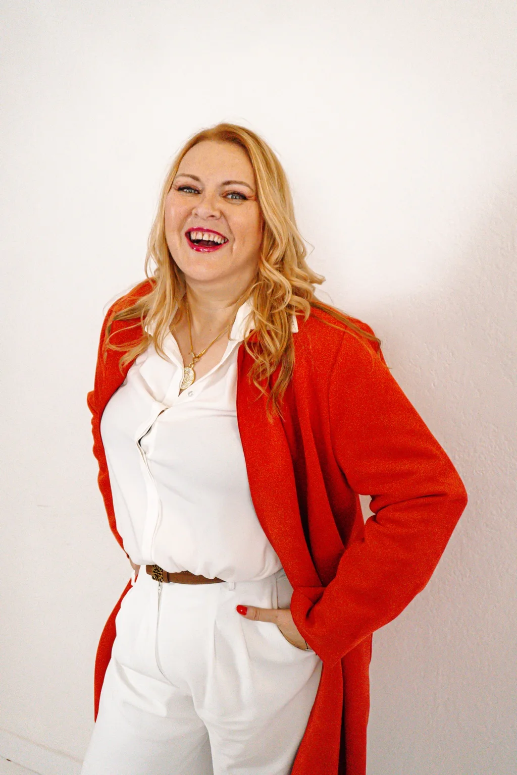 Andrea smiling in a coral coat